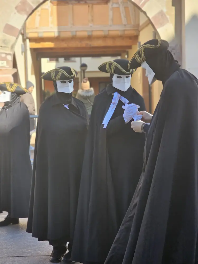 Personnages masqués en noir au carnaval vénitien de Rosheim