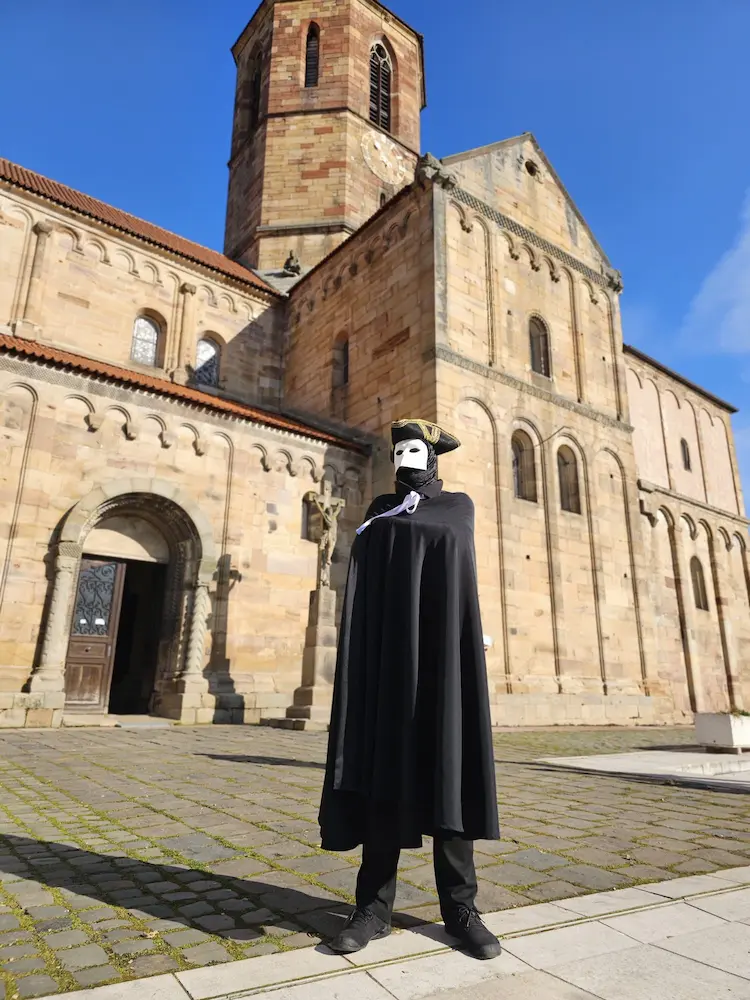 Personnages masqués en noir devant l'église Saint Pierre et Paul de Rosheim